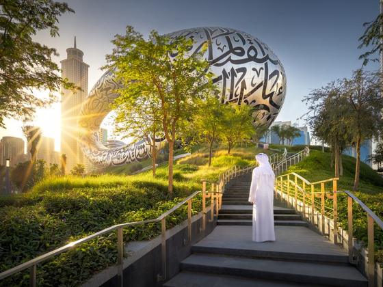 A visitor walking up the garden stairs to the Museum at sunrise